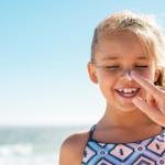 A Mom applies sunscreen to child's face