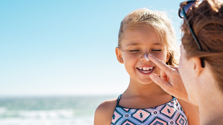 A Mom applies sunscreen to child's face
